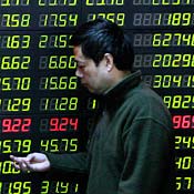 A Chinese investor walks past a stock price board. 