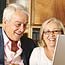 Senior couple sitting at a laptop