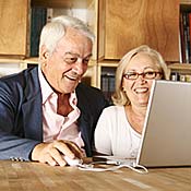 Senior couple sitting at a laptop 