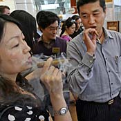 Chinese couple sample cigars at luxury fair 