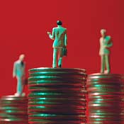 Businessman figures on coin stacks 