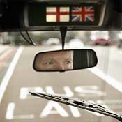 A cabbie in London looks out his rear-view mirror. 