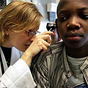 Doctor examines ear of boy 