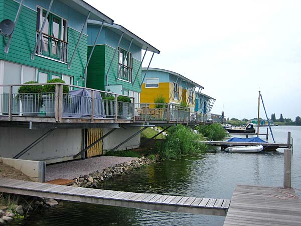 
                Some of the 46 "amphibious houses" in Maasbommel, Netherlands. These sit on dry land by the lakeside. Other a bit farther down the shore sit on piles in the lake itself.
                                    (Rico Gagliano)
                                