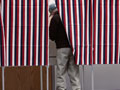A man marks his ballot in a voting booth