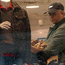 A man considers a shirt as he shops for clothes.