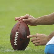 Man holds a football to be kicked 