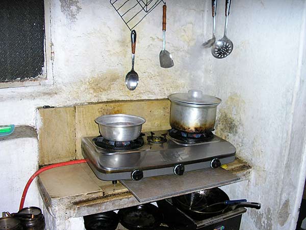 
                The family's "five-star" kitchen. Ayssir cited gas for the hotplate as one of the family's big expenses. The window looks out onto an alley, where people throw trash.
                                    (Alisa Roth)
                                