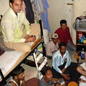 Migrant workers in a room they share in Sonapour 