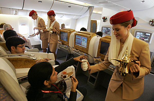 
                Emirates Airlines flight attendants serve passengers during a demonstration flight of the Boeing 777 long-haul aircraft in Dubai in September 2007.
                                    (Karim Sahib/AFP/Getty Images)
                                