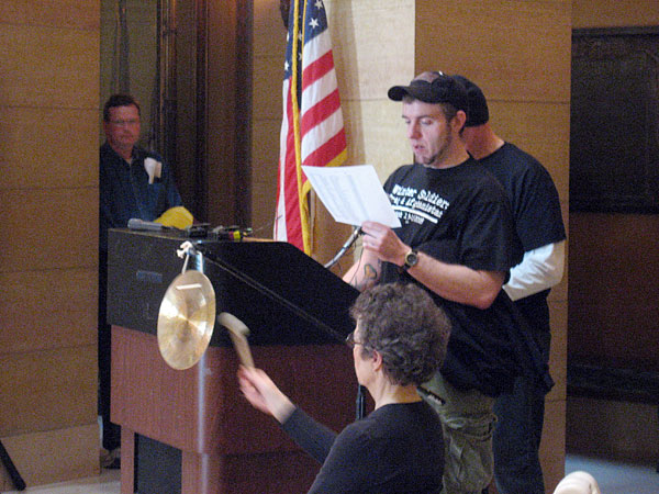 Iraq War veteran Brandon Day reads some of the names of fallen service members in Iraq at the state Capitol in St. Paul. A gong was sounded after each name.
