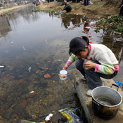 A girl collects water from a ditch in China 