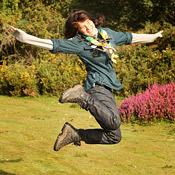 A Girl Scout jumps in the air 