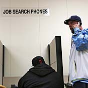 Man uses phone at employment office. 