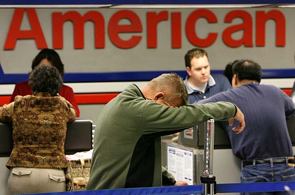 
                Exhausted from traveling, Johnny Sigmon waits in line after his American Airlines flight to Las Vegas was canceled on April 9, 2008, at the Dallas Fort Worth International Airport in Irving, Texas.
                                    (Rick Gershon/Getty Images)
                                