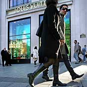 People pass the Louis Vuitton store in Paris 