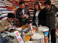 A rice vendor in China calculates prices of rice