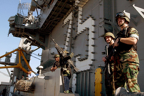 
                    U.S. sailors assigned to security duty stand watch as the aircraft carrier USS Harry S. Truman pulls into the Jebel Ali port facility, near Dubai, United Arab Emirates.
                                            (Ricardo J. Reyes)
                                        