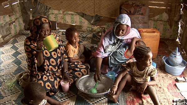 
                A family in Mauritania shares a pudding made from rice, milk and sugar.
                                    (Courtesy of Washington Post / Travis Fox)
                                
