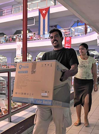 
                A Cuban man carries his new computer bought in a Havana store on May 2, 2008. Cubans are now allowed to purchase computers for personal use, something previously limited to state companies.
                                    (Adalberto Roque/AFP/Getty Images)
                                