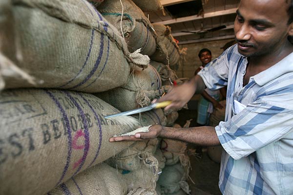 
                An Indian vendor checks the quality of rice at a warehouse in Kolkata.
                                    (Deshakalyan Chowdhury/AFP/Getty Images)
                                