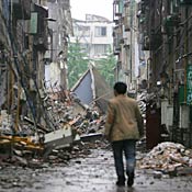 Man walks down a debris-filled street in Dujiangya 