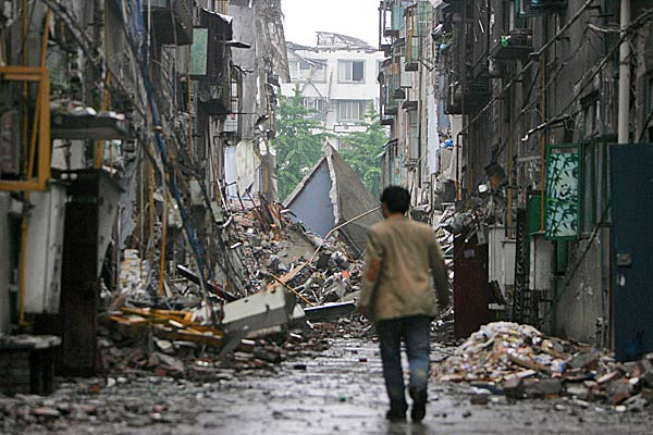
                A man walks down a debris-filled street in Dujiangyan City after Monday's earthquake in Sichuan province, China.
                                    (Feng Li / Getty Images)
                                