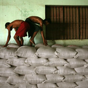 Workers in Myanmar unload rice into a warehouse 