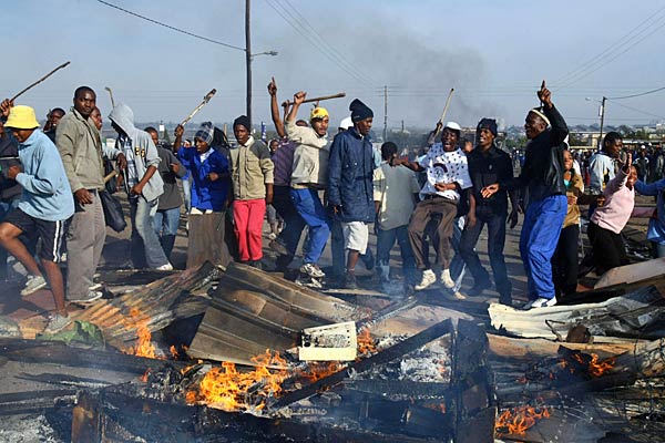 
                Residents of Reiger Park Township near Johannesburg, South Africa, build barricades during clashes with police. At least 13 people were killed and 50 injured.
                                    (AFP/Getty Images)
                                