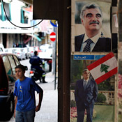 A boy walks past posters in Beirut 