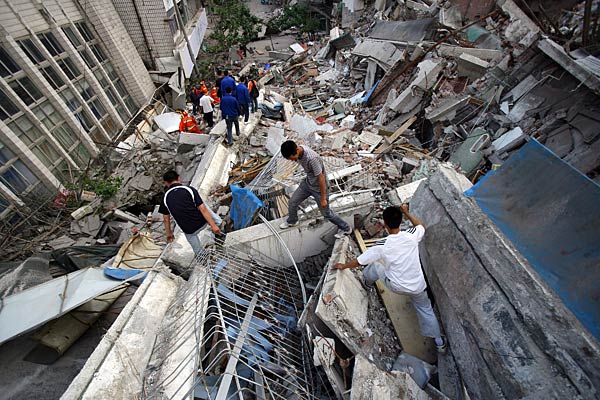 
                Chinese rescuers and volunteers work on the debris of collapsed houses in search of earthquake survivors on May 14, 2008 in Beichuan County, Sichuan Province, China.
                                    (China Photos/Getty Images)
                                