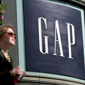A woman walking in front of a Gap store. 