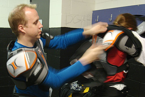 Benjamin Salisbury helps his wife Kelly get suited up before their hockey 