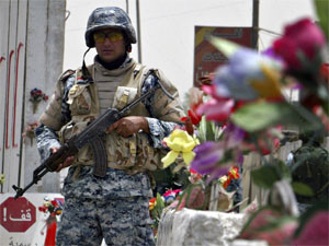 An Iraqi policeman stands guard at a checkpoint decorated with plastic flowers on Palestine street in Baghdad on July 9, 2008. Security continued to improve in Iraq from March to May 2008, with violence at its lowest level in four years, but the gains are 'fragile, reversible and uneven,' a quarterly Pentagon report said.