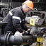 Oil worker adjusts pipe