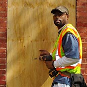 Shawn Chapman boards up a building 