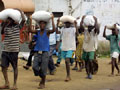 Liberians carry bags of food