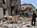 A Georgian man stands among ruins