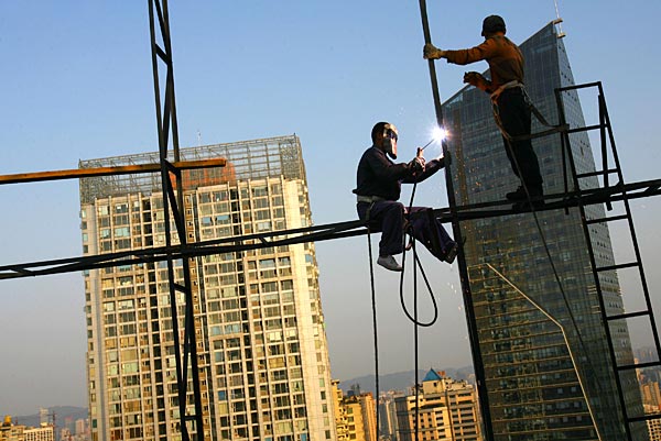 
                Workers weld a stand on the roof of a building at the Guanyinqiao Pedestrian Street in Chongqing Municipality, China.
                                    (China Photos/Getty Images)
                                