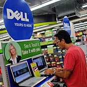 A man looks at a Dell computer at a Staples store 