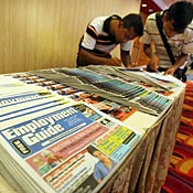 Two men fill out forms at New York City job fair 