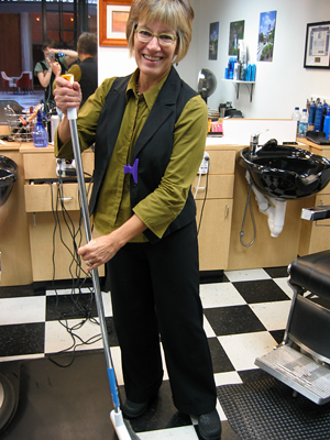 
                Hair stylist Yvonne Curtis sweeps and smiles at Gene's Master Cuts.
                                    (Amy Scott)
                                