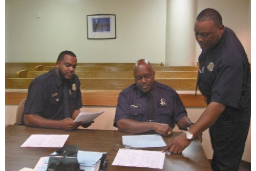 
                    Officers Robert Mingus, Terrance Harris and Alvis Owen prepare for weekend arraignments.
                                            (Desiree Cooper)
                                        