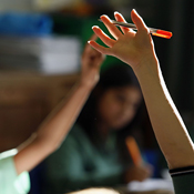Students raise their hands in class 
