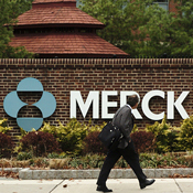 A man walks by a sign at a Merck plant 