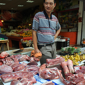 A hawker sells pork at a food market in Xiamen 
