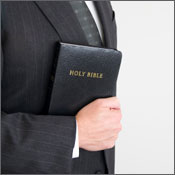 Man in suit holding a Bible 