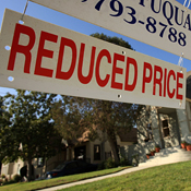 Sign outside a house indicates reduced sale price 