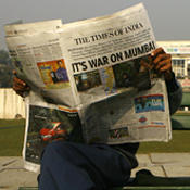 Indian men read newspapers in New Delhi 