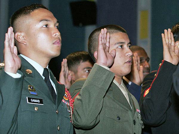 
                Military personnel raise their hands during a naturalization ceremony for the military in October at Pope Air Force Base, N.C.
                                    (Logan Mock-Bunting / Getty Images)
                                